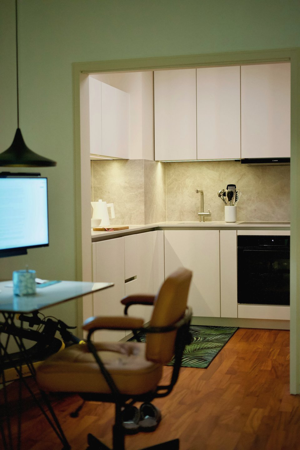 Bureau à domicile donnant sur une cuisine blanche moderne